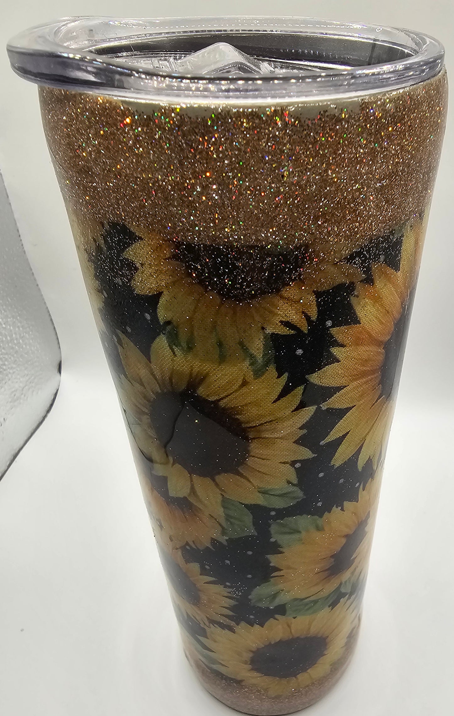 Tumbler with sunflower design and glittery gold base on a white background